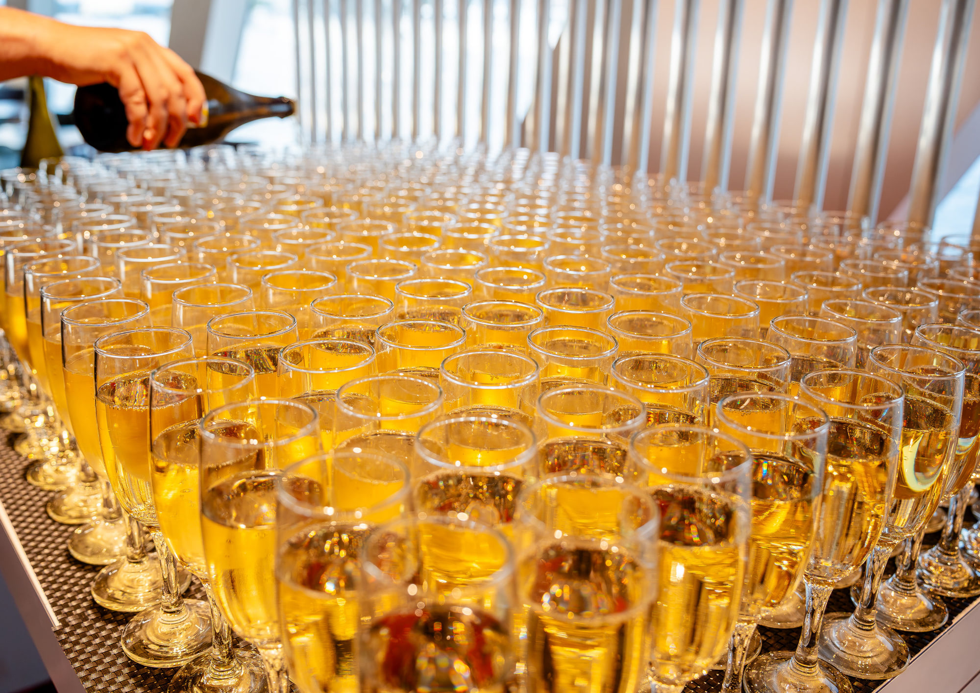 Glasses of prosecco being prepared for guests aboard a Bud By Boat cruise.