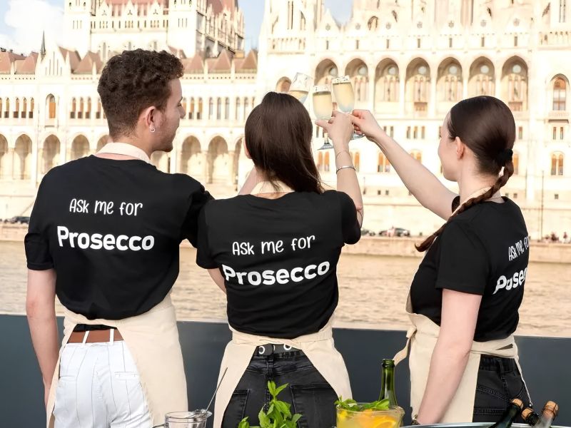 Bud By Boat crew raising Prosecco glasses in front of the Hungarian Parliament